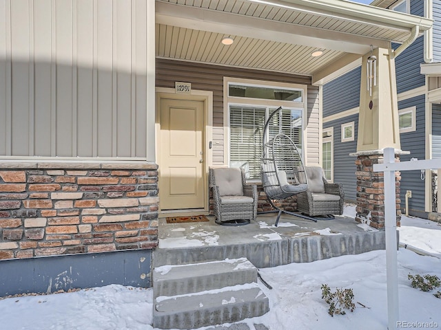 snow covered property entrance featuring a porch