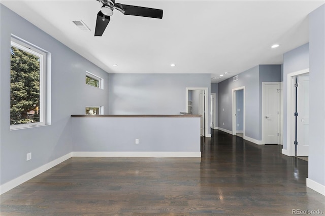 unfurnished living room with ceiling fan and dark wood-type flooring