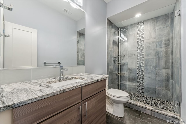 bathroom with vanity, toilet, and a shower with shower door