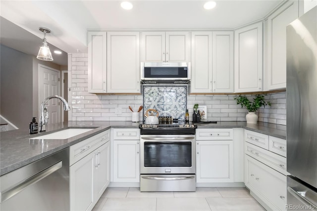 2645 S Xanadu Way Unit D, Aurora, CO 80014 - kitchen with stainless steel appliances, tasteful backsplash, white cabinets, light tile patterned floors, and recessed lighting