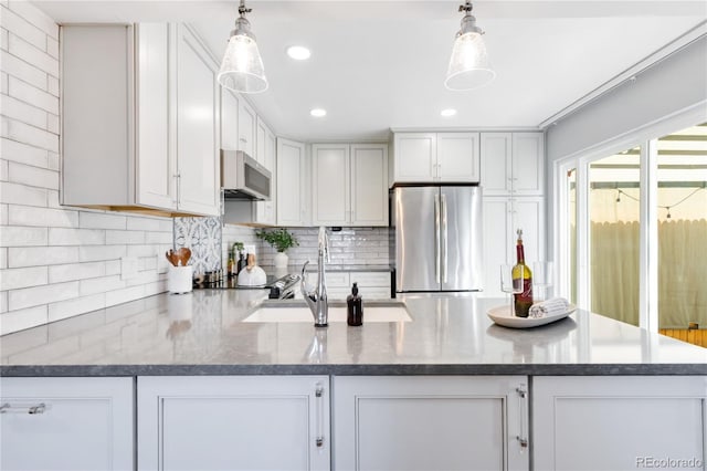 2645 S Xanadu Way Unit D, Aurora, CO 80014 - kitchen featuring stainless steel appliances, backsplash, a peninsula, hanging light fixtures, and white cabinets