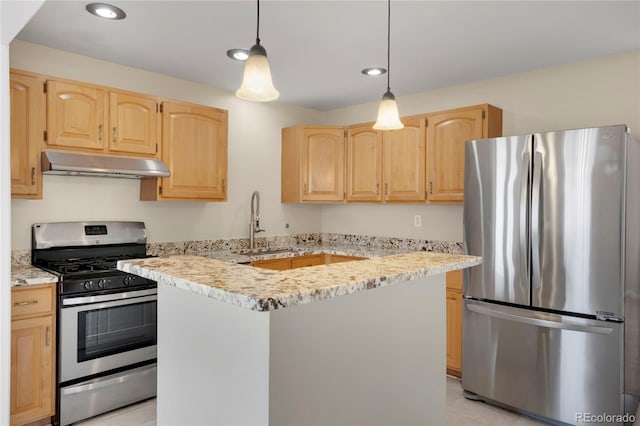kitchen featuring appliances with stainless steel finishes, under cabinet range hood, light brown cabinets, a sink, and hanging light fixtures