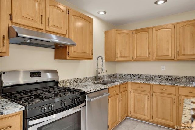 kitchen featuring stainless steel appliances, under cabinet range hood, a sink, light brown cabinets, and recessed lighting