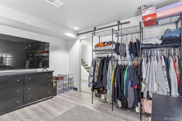 walk in closet with light hardwood / wood-style flooring