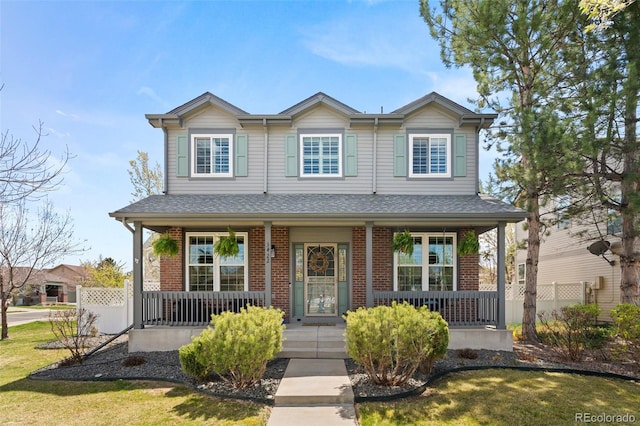 3422 W 125th Dr, Broomfield, CO 80020 - view of front of home with covered porch, brick siding, fence, and a front lawn
