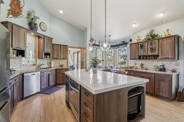 30206 Telluride Ln, Evergreen, CO 80439 - kitchen with stainless steel appliances, open shelves, decorative backsplash, light wood-type flooring, and high vaulted ceiling