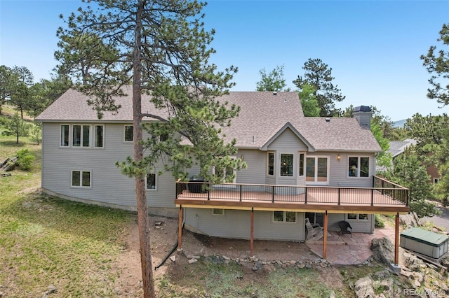 30206 Telluride Ln, Evergreen, CO 80439 - rear view of property featuring a wooden deck, a chimney, a patio area, roof with shingles, and a lawn