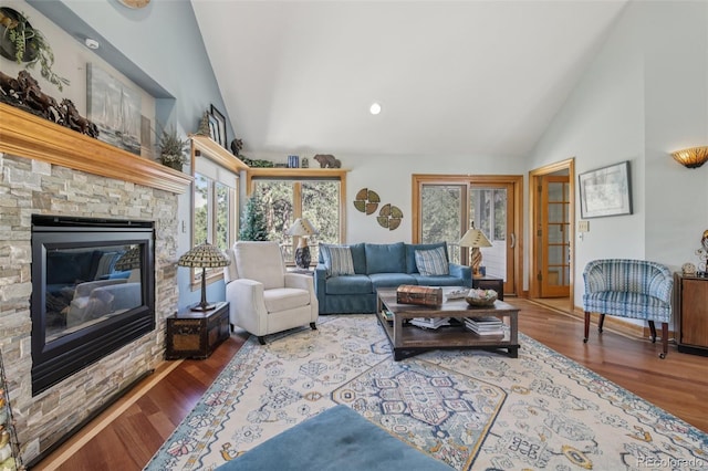 30206 Telluride Ln, Evergreen, CO 80439 - living room with high vaulted ceiling, a stone fireplace, and wood finished floors