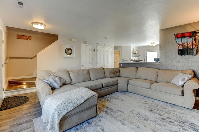 living area with wood finished floors and a textured ceiling