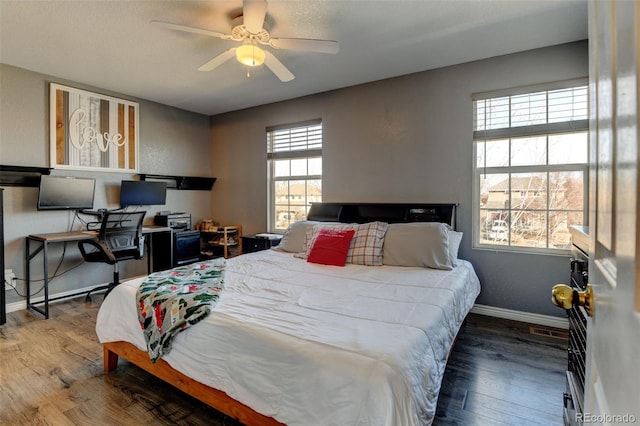 bedroom with ceiling fan, baseboards, and wood finished floors