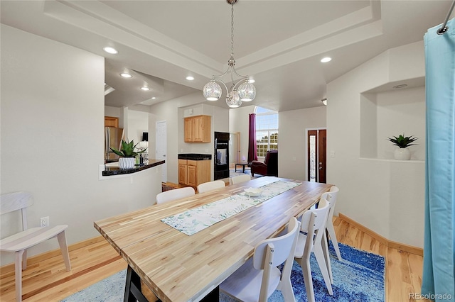 11770 Leavenworth Dr, Conifer, CO 80433 - dining area with a notable chandelier, a tray ceiling, recessed lighting, baseboards, and light wood finished floors