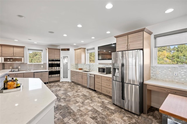 kitchen with appliances with stainless steel finishes, backsplash, and sink