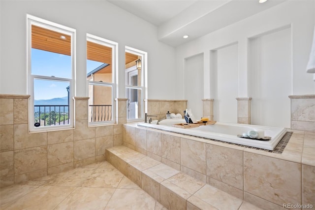 bathroom featuring a mountain view, tiled bath, and tile patterned flooring