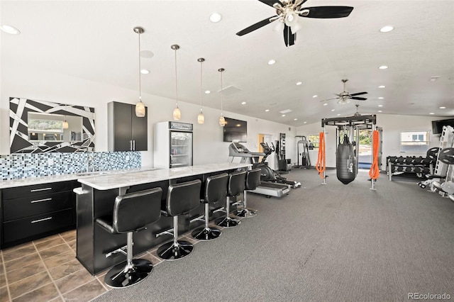 workout area featuring carpet flooring, vaulted ceiling, sink, and ceiling fan