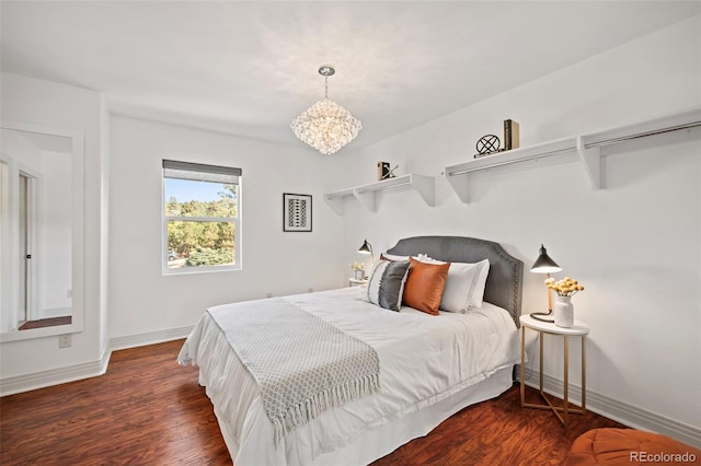 bedroom featuring an inviting chandelier and dark hardwood / wood-style flooring