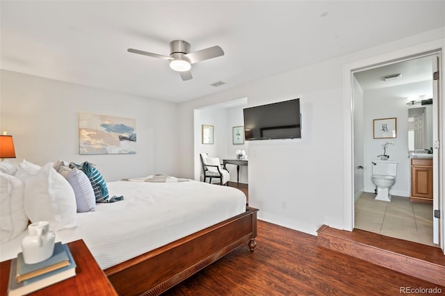 bedroom with connected bathroom, dark hardwood / wood-style floors, and ceiling fan