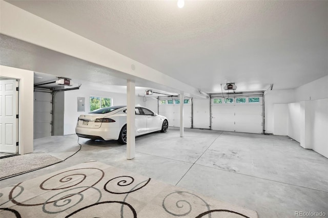 garage featuring electric panel, a garage door opener, and a carport