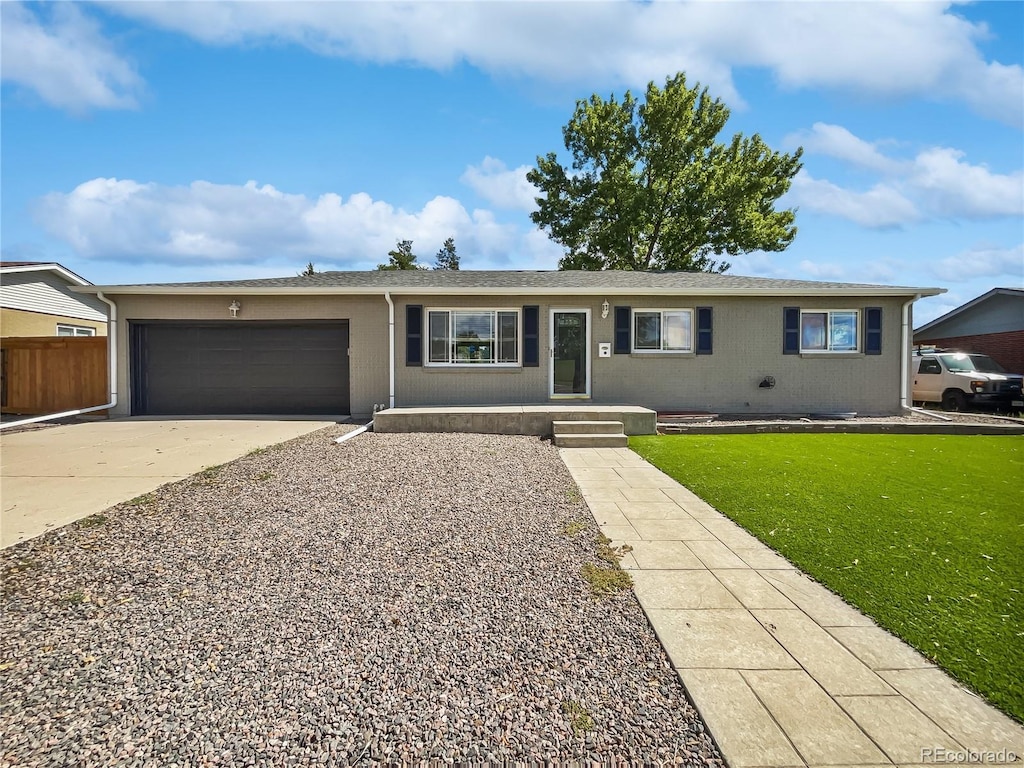 ranch-style home with a garage and a front lawn