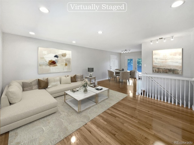 living room featuring rail lighting and hardwood / wood-style floors