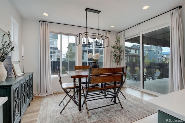 dining space with light wood-type flooring and a chandelier