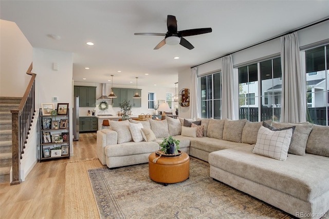 living room featuring light hardwood / wood-style flooring and ceiling fan