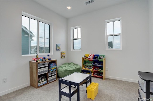 recreation room featuring a wealth of natural light and light carpet