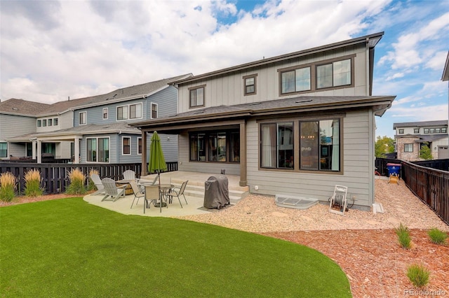 rear view of house with a yard and a patio