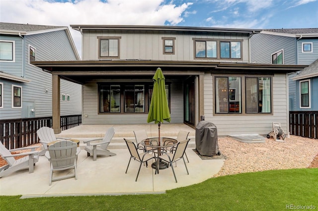 back of property with a fire pit and a patio