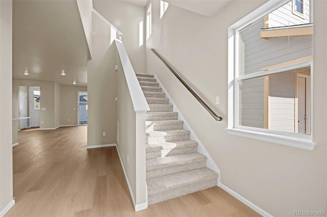 stairs featuring a healthy amount of sunlight and wood-type flooring