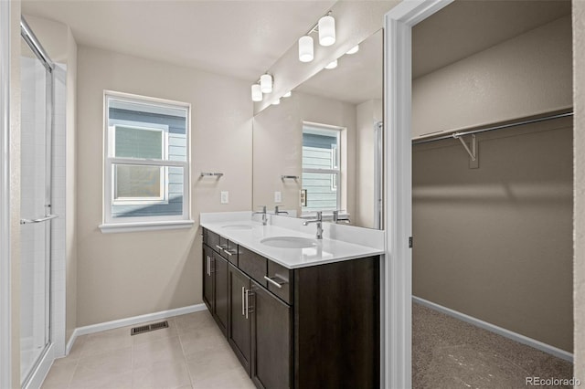 bathroom featuring tile patterned floors, vanity, and a shower with door