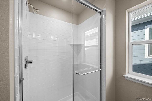 bathroom with a shower with door