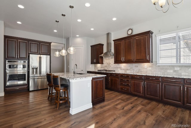 12938 Bridge View Ln, Parker, CO 80134 - kitchen with stainless steel appliances, wall chimney exhaust hood, a sink, dark wood-type flooring, and recessed lighting