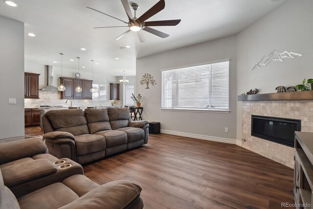 12938 Bridge View Ln, Parker, CO 80134 - living room with ceiling fan, dark wood-style flooring, baseboards, recessed lighting, and a glass covered fireplace