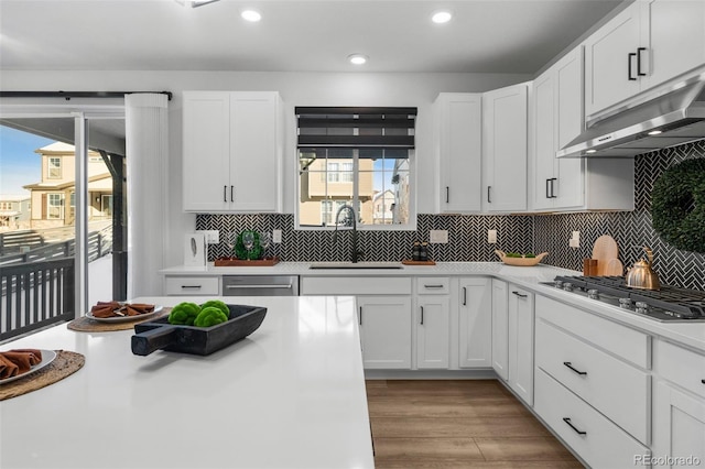 kitchen with sink, light hardwood / wood-style flooring, white cabinets, and appliances with stainless steel finishes