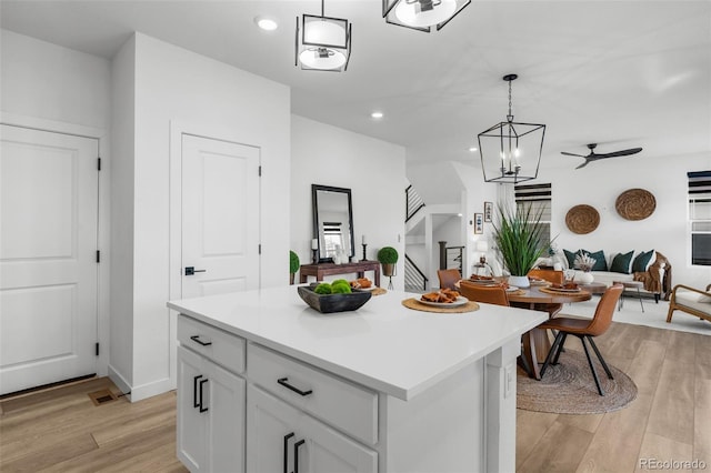 kitchen featuring decorative light fixtures, light hardwood / wood-style floors, and a kitchen island