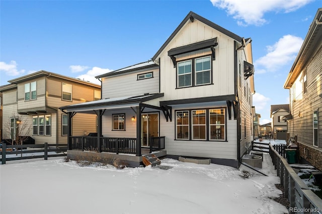 snow covered property featuring covered porch