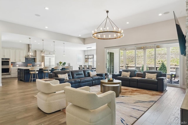 547 Scrubjay Cir, Castle Rock, CO 80104 - living room featuring light wood-style floors, a chandelier, recessed lighting, and a towering ceiling