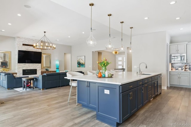 547 Scrubjay Cir, Castle Rock, CO 80104 - kitchen featuring appliances with stainless steel finishes, open floor plan, light wood-style floors, backsplash, and recessed lighting
