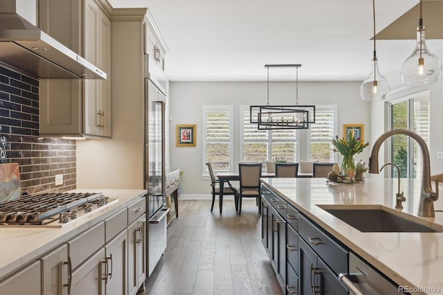 547 Scrubjay Cir, Castle Rock, CO 80104 - kitchen featuring wall chimney range hood, appliances with stainless steel finishes, decorative backsplash, decorative light fixtures, and light stone countertops