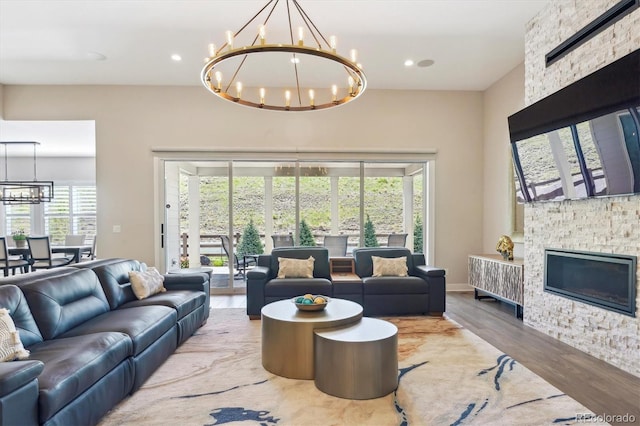 547 Scrubjay Cir, Castle Rock, CO 80104 - living area with a chandelier, healthy amount of natural light, a stone fireplace, wood finished floors, and recessed lighting