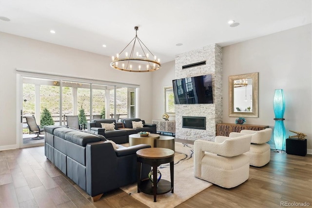 547 Scrubjay Cir, Castle Rock, CO 80104 - living room featuring wood finished floors, a chandelier, recessed lighting, and a stone fireplace