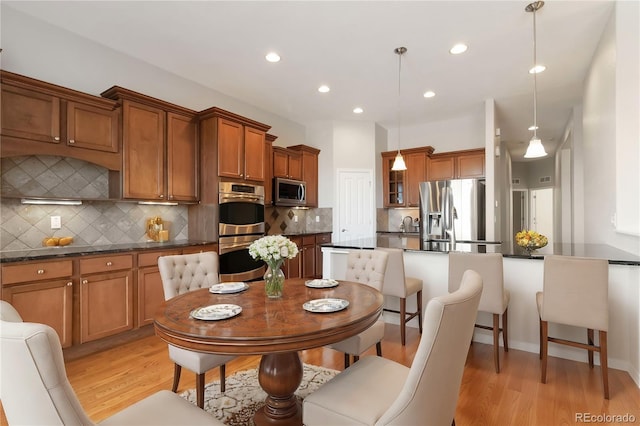 dining area with light wood-style flooring and recessed lighting