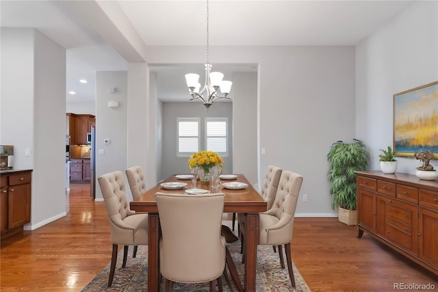 dining space with a chandelier, recessed lighting, light wood-style flooring, and baseboards