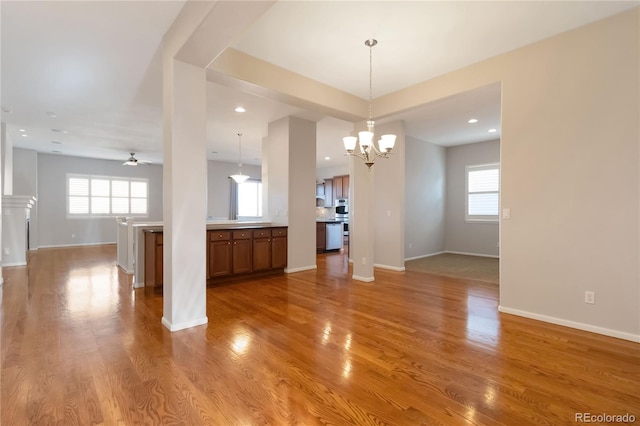 interior space featuring light wood-type flooring, baseboards, and a healthy amount of sunlight