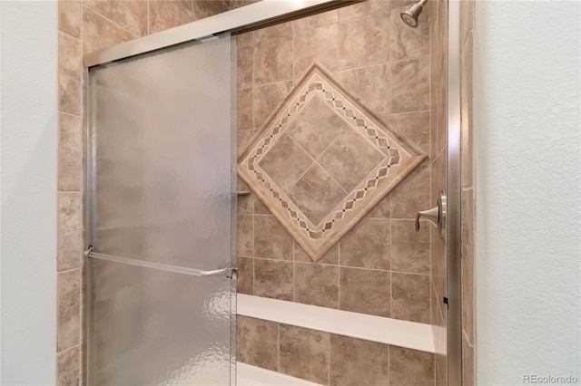 full bathroom with a stall shower and a textured wall