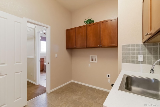 clothes washing area featuring baseboards, hookup for a washing machine, cabinet space, hookup for an electric dryer, and a sink