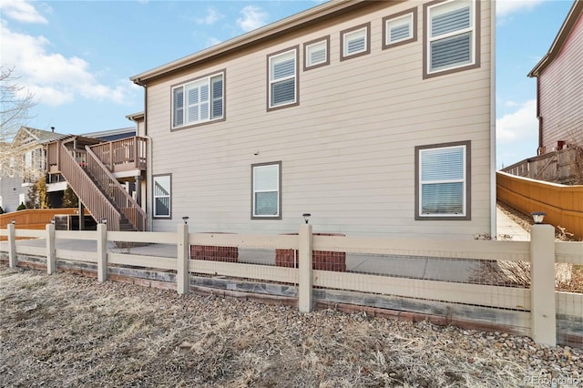 back of property with stairway, a deck, and a fenced backyard