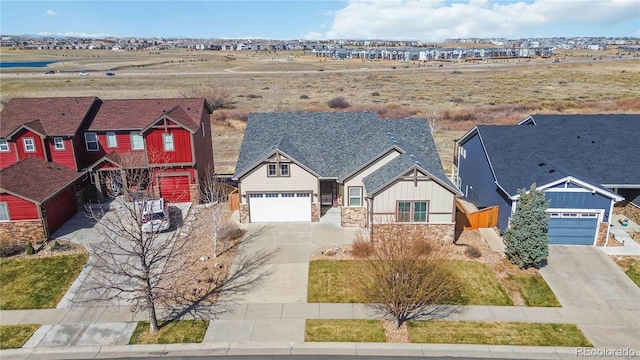 view of front of home with stone siding, board and batten siding, driveway, and a garage