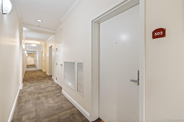 hall with ornamental molding and carpet flooring