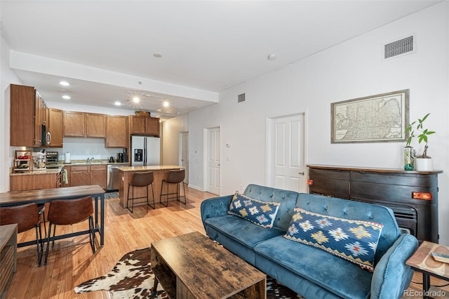 living room with sink and light wood-type flooring